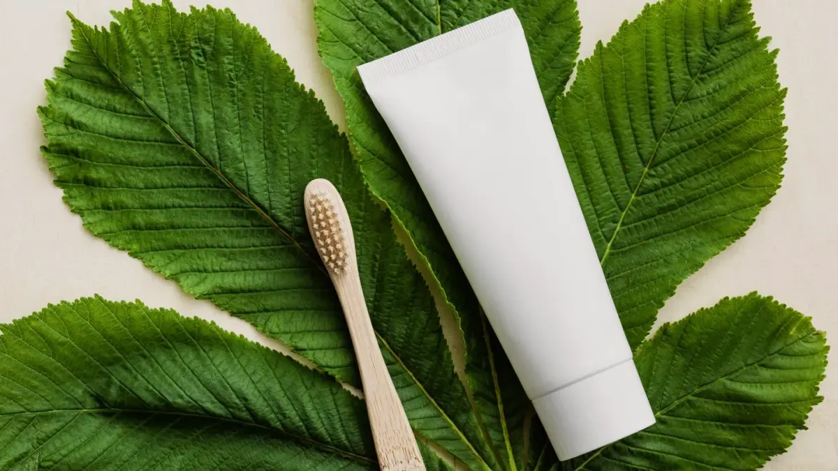 A dog-sized toothbrush laid next to a tube of toothpaste on a bathroom counter