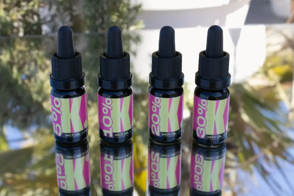 A dropper bottle of hemp oil positioned near a small dog
