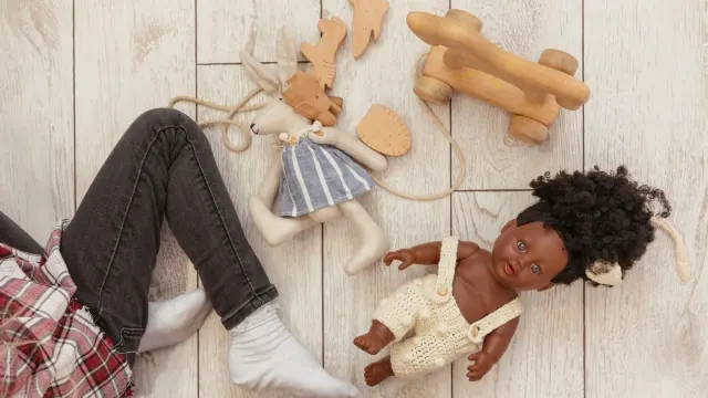 A mix of rubber, rope, and plush dog toys arranged on a wood floor