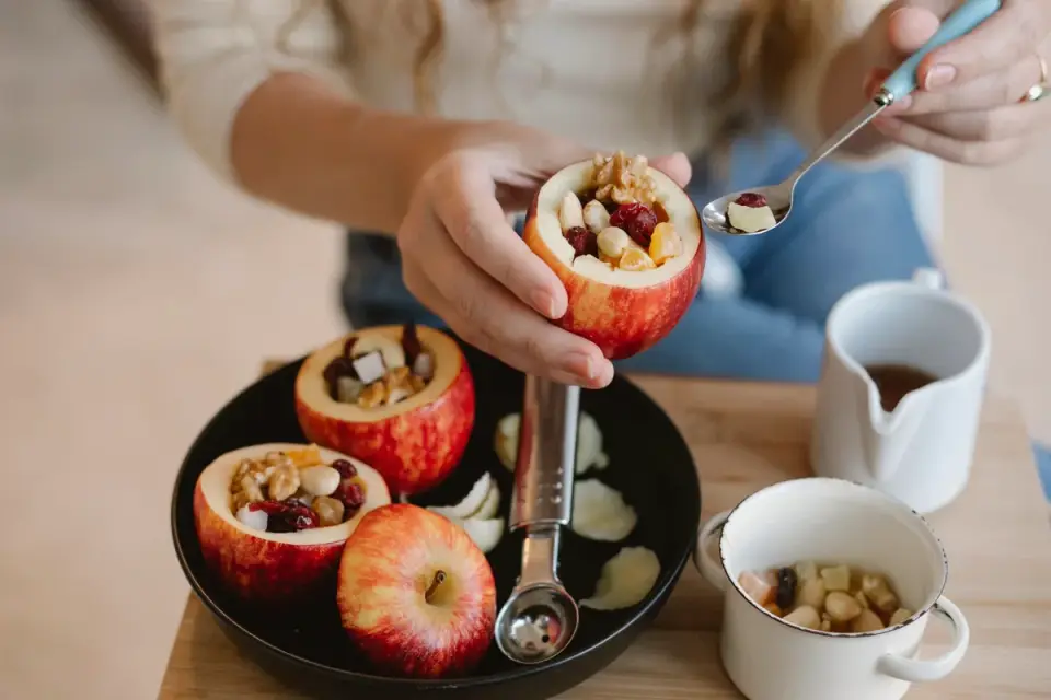 A person slicing an apple and removing the core before giving pieces to a dog