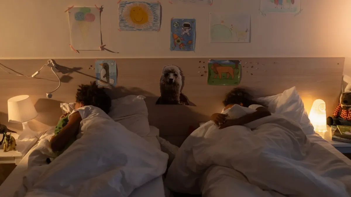 A small dog curled up and resting on a bed under soft evening light