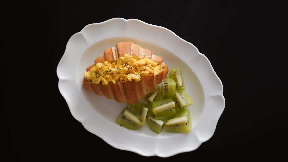 A small portion of plain scrambled egg served beside a dog's regular kibble