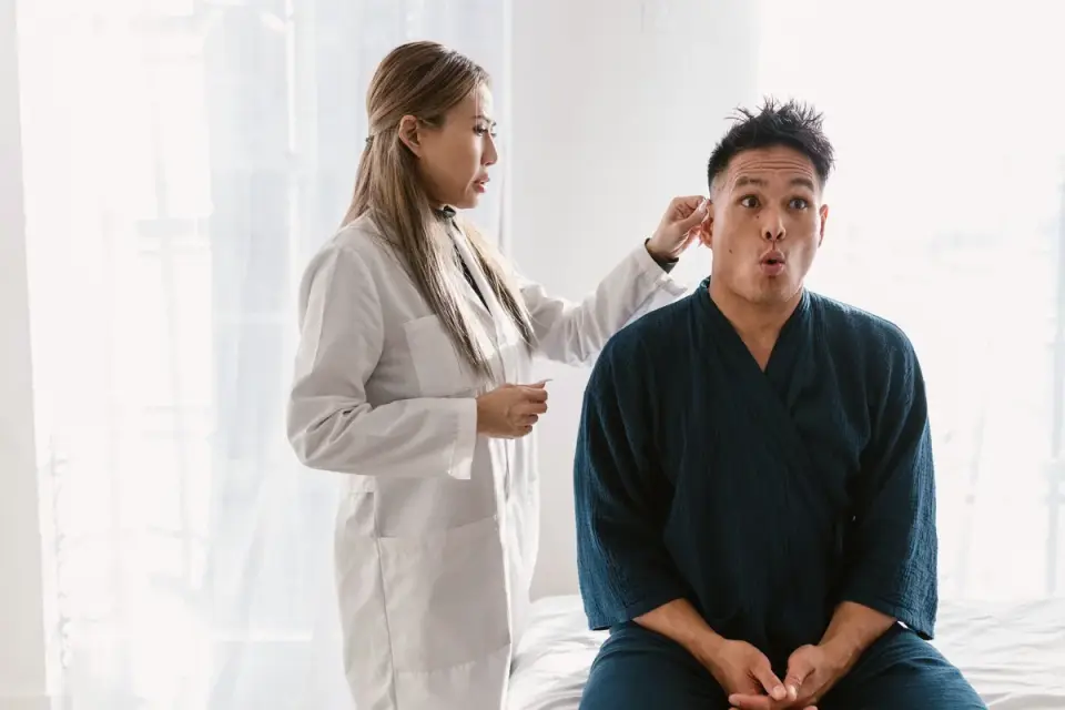 A veterinarian gently examining a dog's ear canal with an otoscope