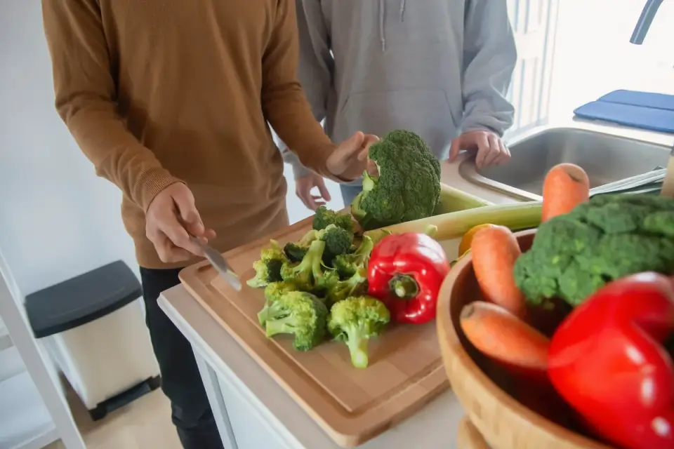 Chopped broccoli florets and a stalk on a wooden cutting board