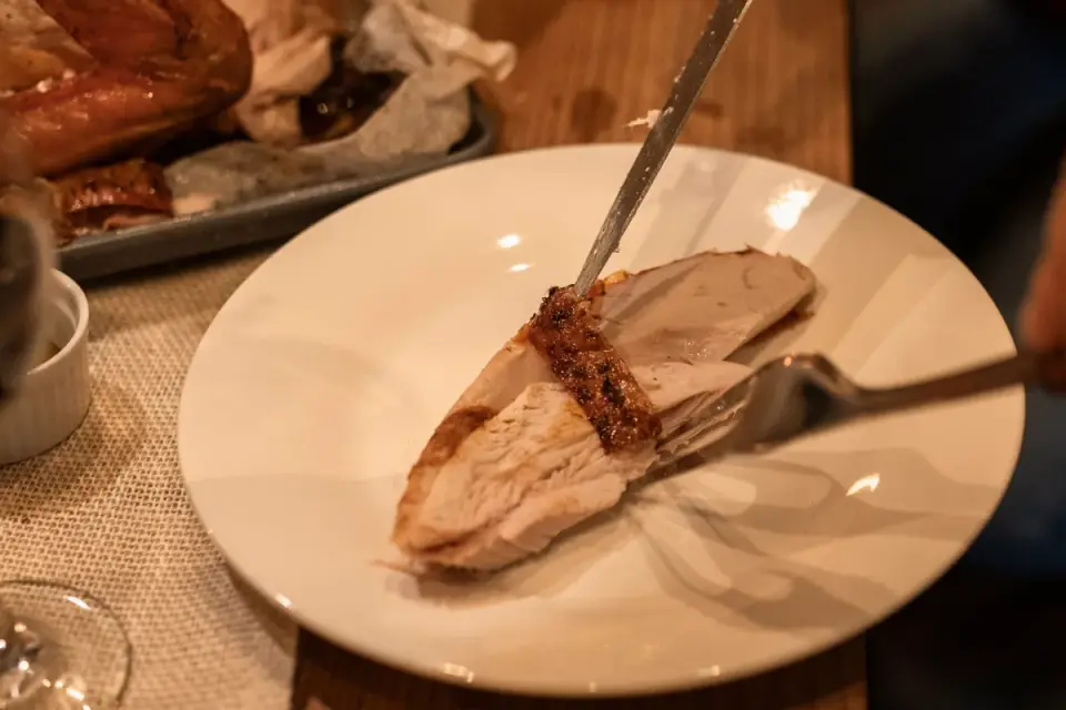 Golden retriever sniffing at turkey skin left on a kitchen counter