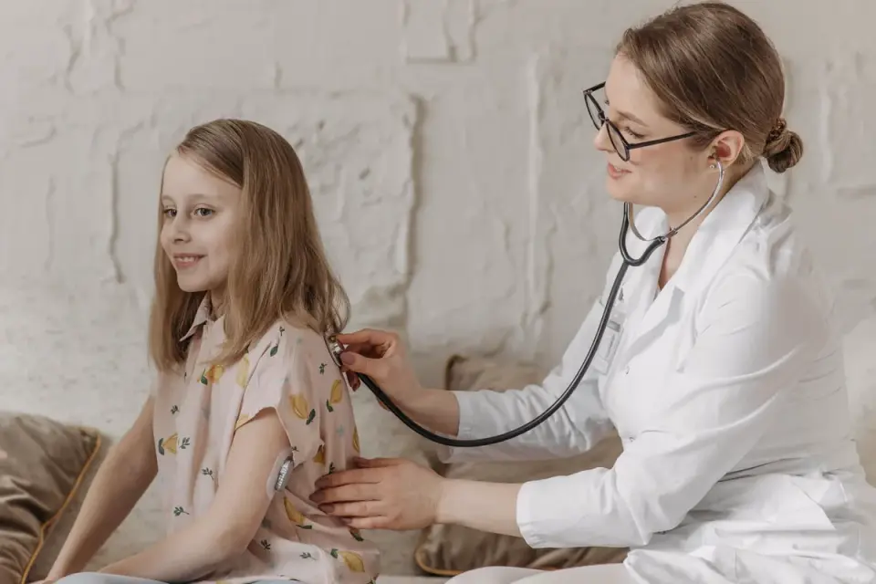 Veterinarian listening to a small spaniel&#x27;s chest with a stethoscope